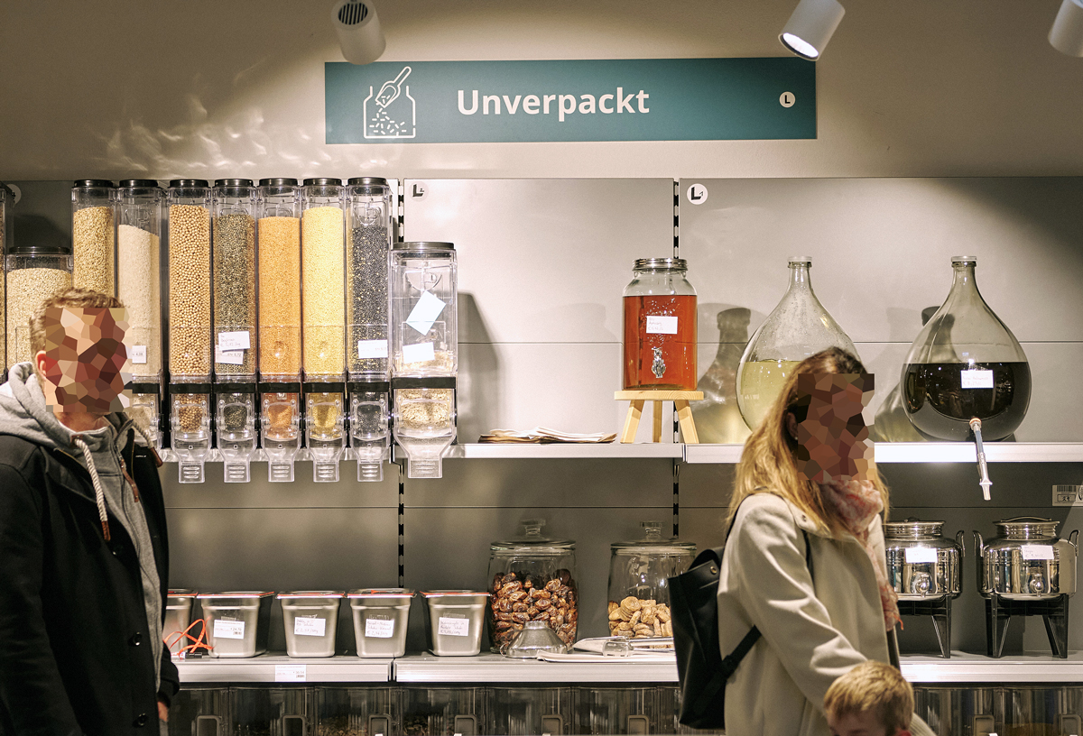 Unverpackt-Regal im MILA Mitmach-Supermarkt mit Inhalt und Beschriftung darüber.